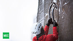 <strong>Gear Choices</strong></br>
                        Having to climb with camera gear is painful.  I often have to make a choice of which lenses to take and which to leave behind.  This day, the f2.8 tele weighed my harness down like an anchor.  I cursed it the entire way up to the belay.  Climbing shots tend to be very wide, to show the background and the exposure of the route.  Here, the climber might have been standing on the ground next to his pack and not several pitches up.  Yet this is one of my favorite shots from the entire day as it show off the axes like no other frame.  I was glad that the photo editor at MEC agreed.
